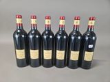 six bottles of red wine lined up in a row