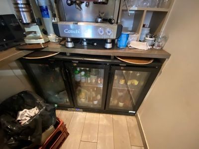 a small kitchen with a refrigerator and a coffee maker