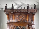 a wooden grandfather clock with carvings on the top of it