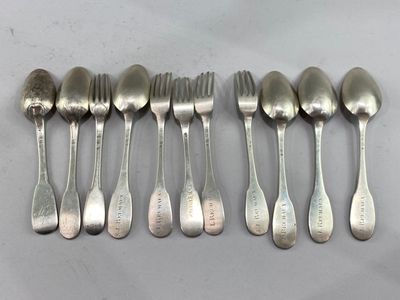 six spoons and six forks are lined up on a table