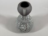 a black and white vase sitting on a white surface