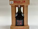 une bouteille de rhum posée sur un support en bois et portant une étiquette