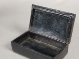a small black box sitting on a white surface