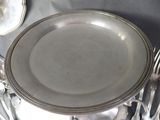 a silver plate on a table with silverware on it