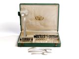 a green case with silverware in it on a white surface