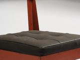 a wooden chair with a black cushion on it
