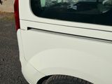 une camionnette blanche garée sur un parking près d'un immeuble