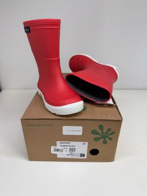 une boîte sur laquelle est posée une paire de bottes de pluie rouges