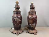 une paire de grands vases en bronze ornés de chevaux, posés sur une table