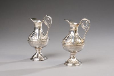 two silver vases with handles and handles on a white surface