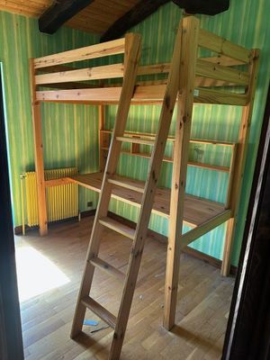 un lit superposé en bois avec une échelle dans une chambre