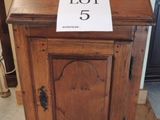 un petit meuble en bois surmonté d'une pancarte