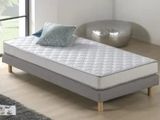 un lit sur lequel est posé un matelas dans une pièce
