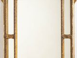 un miroir au cadre doré ouvragé, surmonté d'un oiseau