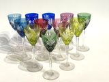 six wine glasses sitting in a row on a white surface