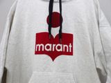 the hoodie is white with a red and black logo on it