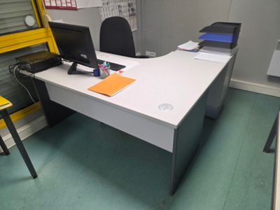 un bureau avec un ordinateur et une chaise dans une pièce
