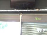 a television mounted on the wall above a row of stationary exercise bikes
