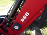 a close up of a red tractor parked on the side of the road