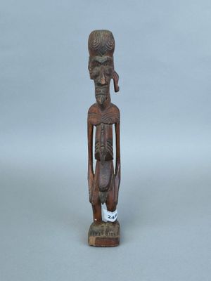 une vieille statue en bois d'un homme avec un chapeau sur la tête