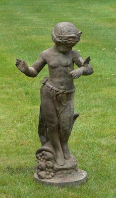 une statue représentant un garçon tenant un oiseau dans un champ