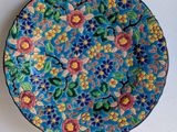 an image of a colorful plate with flowers and leaves on it