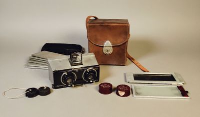 un sac en cuir marron contenant un appareil photo et d'autres objets, posé sur la table