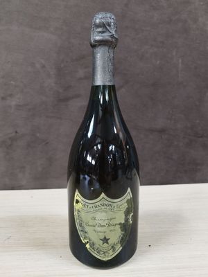 une vieille bouteille de champagne posée sur une table en bois, sur fond marron