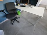 a white desk with a black chair and a computer on it