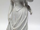statue of a woman in a white dress holding a bird