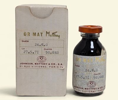 une petite bouteille de liquide posée à côté d'une boîte
