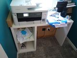 a printer sitting on top of a desk in the corner of a room