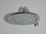 a shower head in a tiled bathroom with blue and white tiles