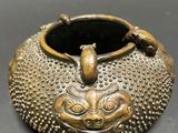 an antique bronze teapot with a bird on top