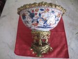 un grand saladier posé sur un support recouvert d'une nappe rouge