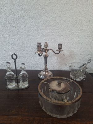 a glass bowl on a table with a candle holder and other items