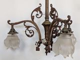 a chandelier with three glass lamps hanging from it