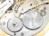 a close up of a gold watch with gears on it