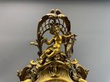 une horloge en or surmontée d'une statue