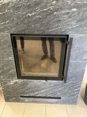 un homme debout devant une cheminée dans une salle de bains