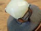 a ring with a white stone sitting on top of a rock