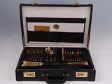 a black case with silverware in it on a white surface