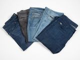 five pairs of jeans stacked on top of each other