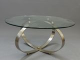 une table en verre avec une base en métal et un plateau en verre