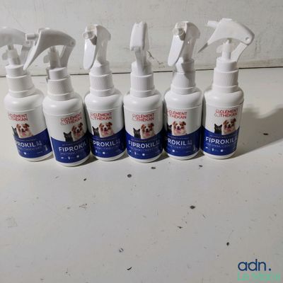 six spray bottles of pet grooming products lined up on a counter
