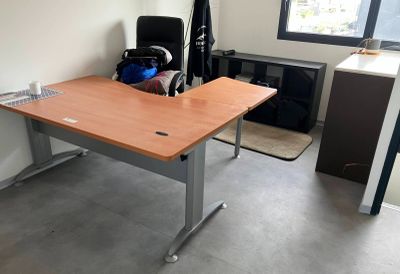 a desk with a chair and a book case in the corner