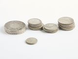 Des pièces sont éparpillées sur une surface blanche, avec une petite pièce au premier plan