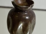 un petit vase posé sur une table en verre