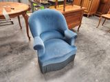 une chaise bleue qui se trouve au milieu d'une pièce