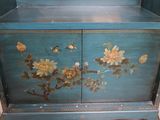 a blue cabinet with flowers and birds painted on it
